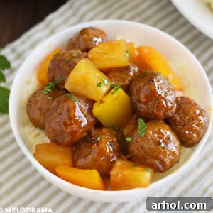 Sweet and sour meatballs with pineapple and yellow bell peppers in a white bowl