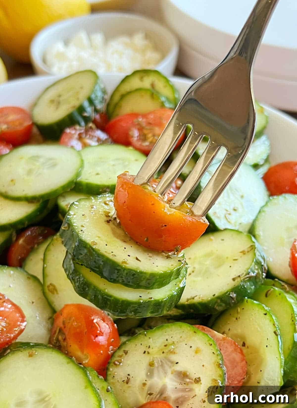 A single fork holding a spoonful of the vibrant cucumber tomato salad, showcasing the fresh ingredients and inviting texture.