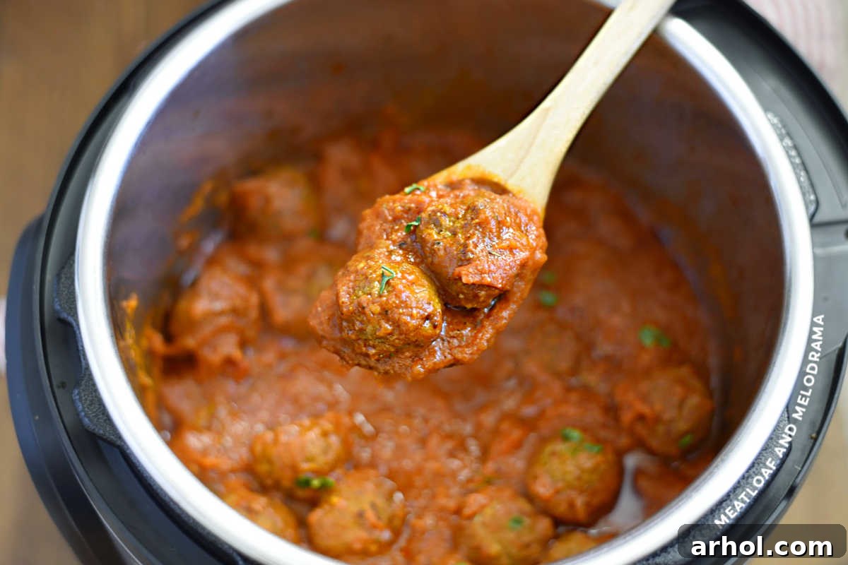 cooked meatballs in sauce in wooden spoon over instant pot