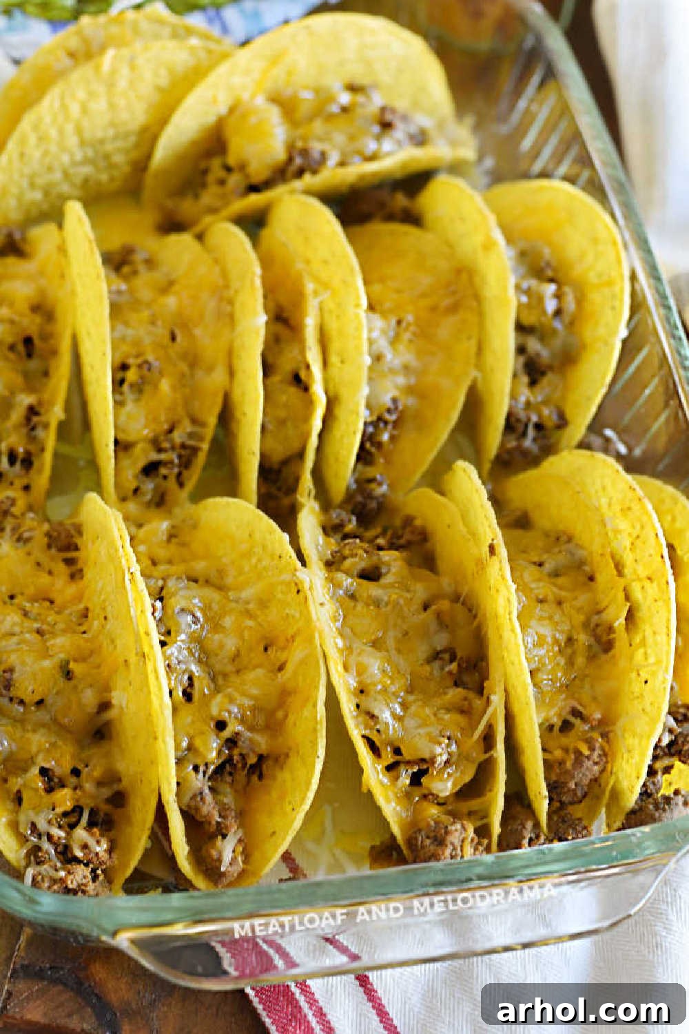 Melted cheese cascading over seasoned ground beef in crispy baked taco shells, fresh from the oven and ready to serve
