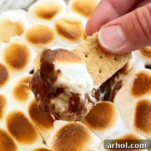 easy smores dip with melted chocolate and gooey marshmallows on a graham cracker