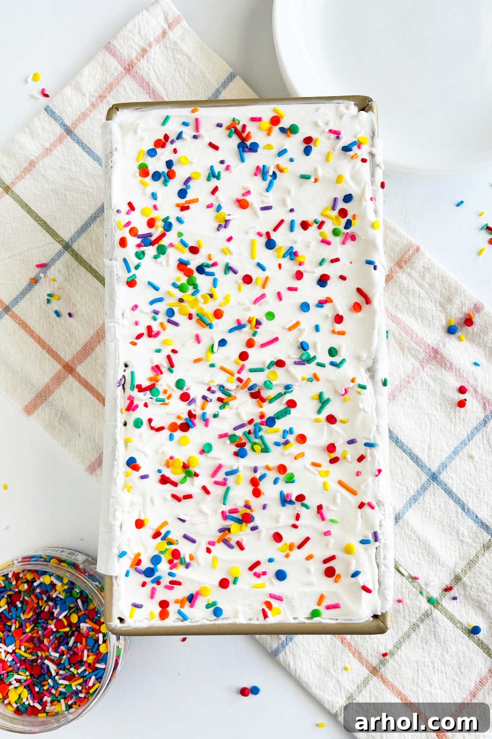 Effortless Ice Cream Sandwich Cake 2 Delicious Ice Cream Sandwich Cake with colorful sprinkles in a loaf pan, ready to serve.