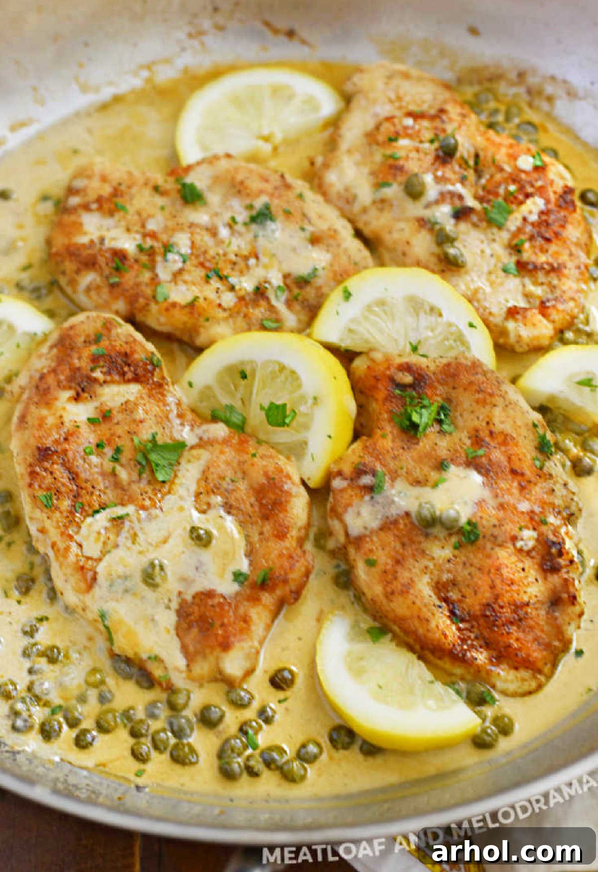 Lemon Chicken Piccata with creamy lemon butter sauce, white wine, and capers, served in a skillet.