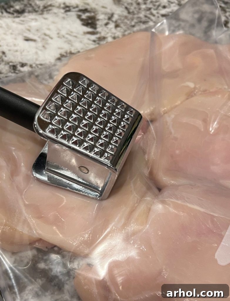 Pounding chicken breasts with a meat mallet in a zip-top bag to create thin cutlets.