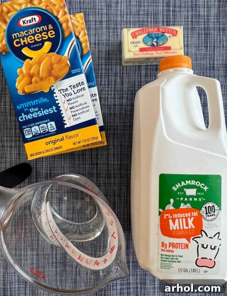 Creamy Instant Pot Kraft Mac and Cheese 3 Ingredients for Instant Pot Kraft Mac and Cheese: blue box Kraft macaroni, butter, milk, and water on a wooden surface.