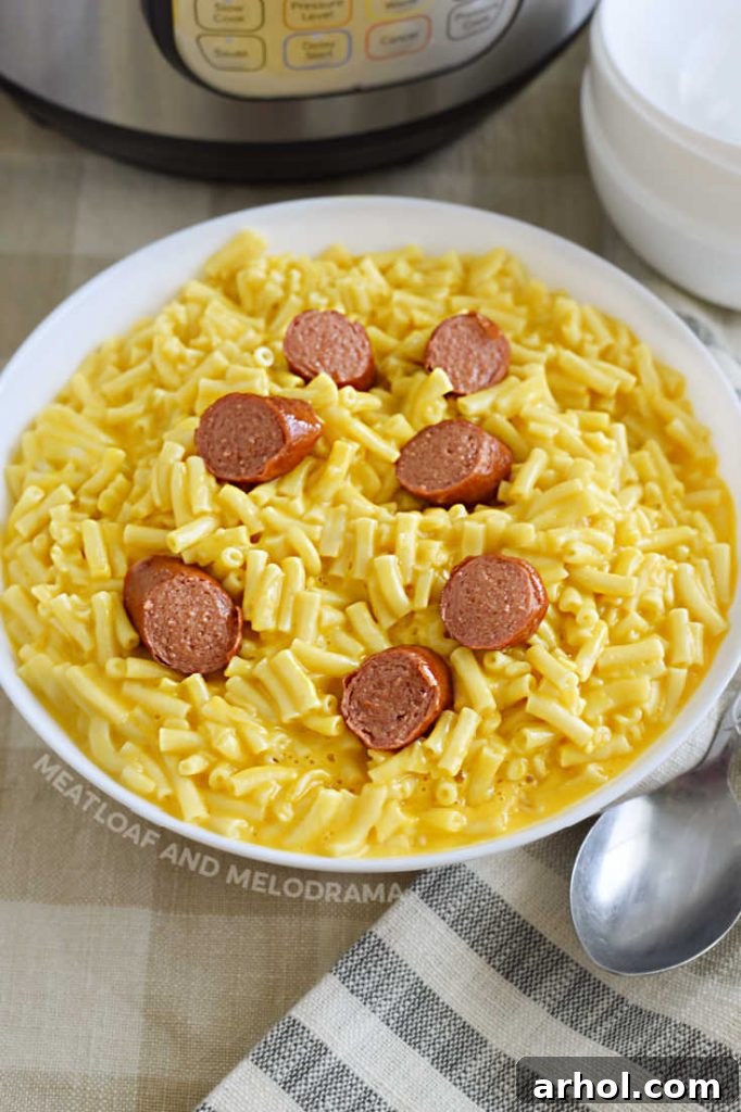 Creamy Instant Pot Kraft Mac and Cheese 8 A bowl of creamy Kraft Mac and Cheese with sliced hot dogs stirred in, a perfect kid-friendly meal.