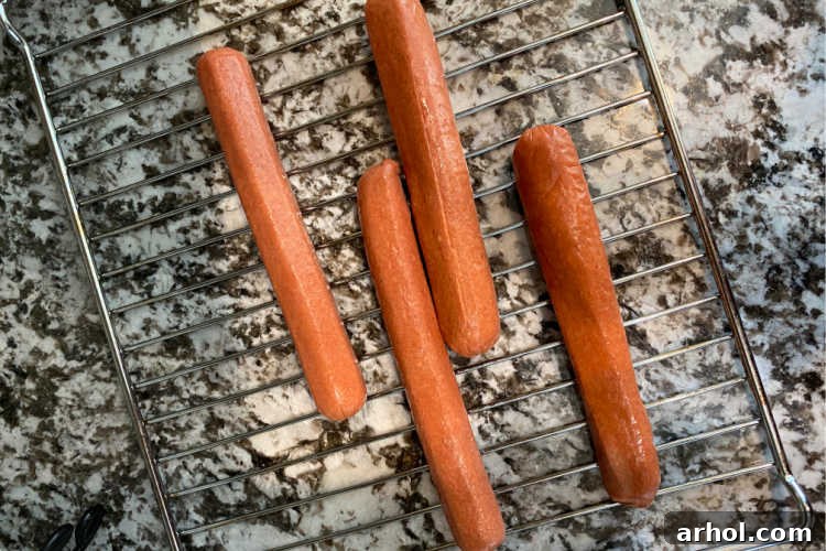 uncooked hot dogs on an air fryer oven rack