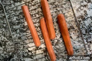 uncooked hot dogs on an air fryer oven rack