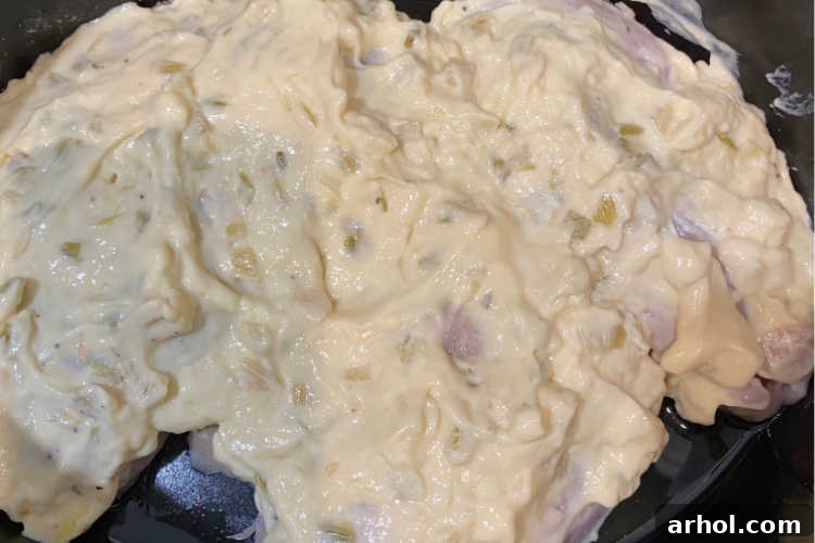 Chicken breasts covered with a creamy mixture of cream of celery soup and sour cream in a slow cooker