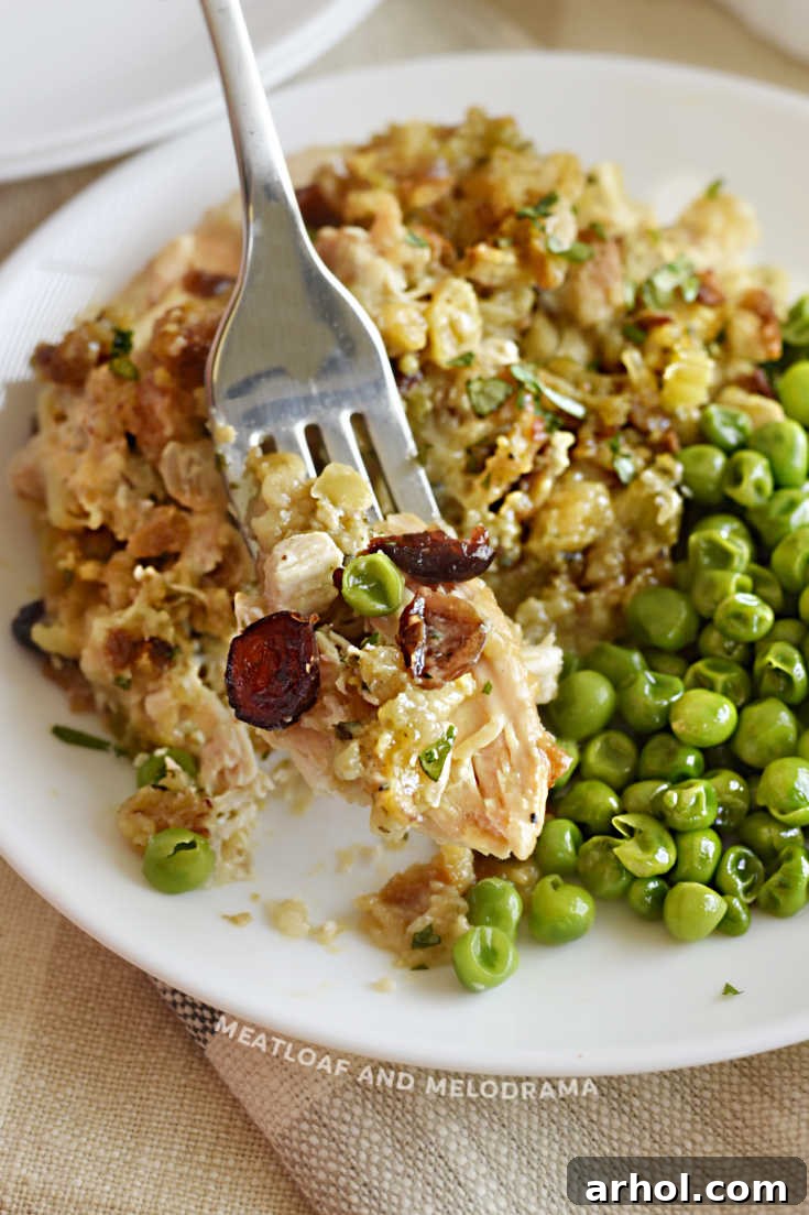 Close-up of slow cooker Thanksgiving chicken with cranberries on a fork, served with green peas