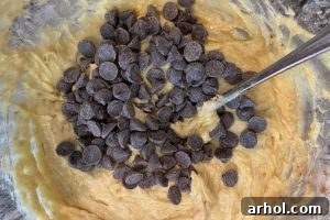 Banana cookie batter with chocolate chips mixed in a bowl.