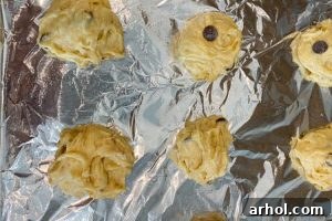 Unbaked cookie dough drops on a lined baking sheet.