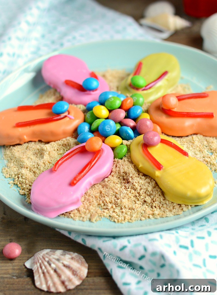 nutter butter easy flip flop cookies with candy melts and skittles and twizzlers on plate with crushed graham crackers, presented as a beach scene.