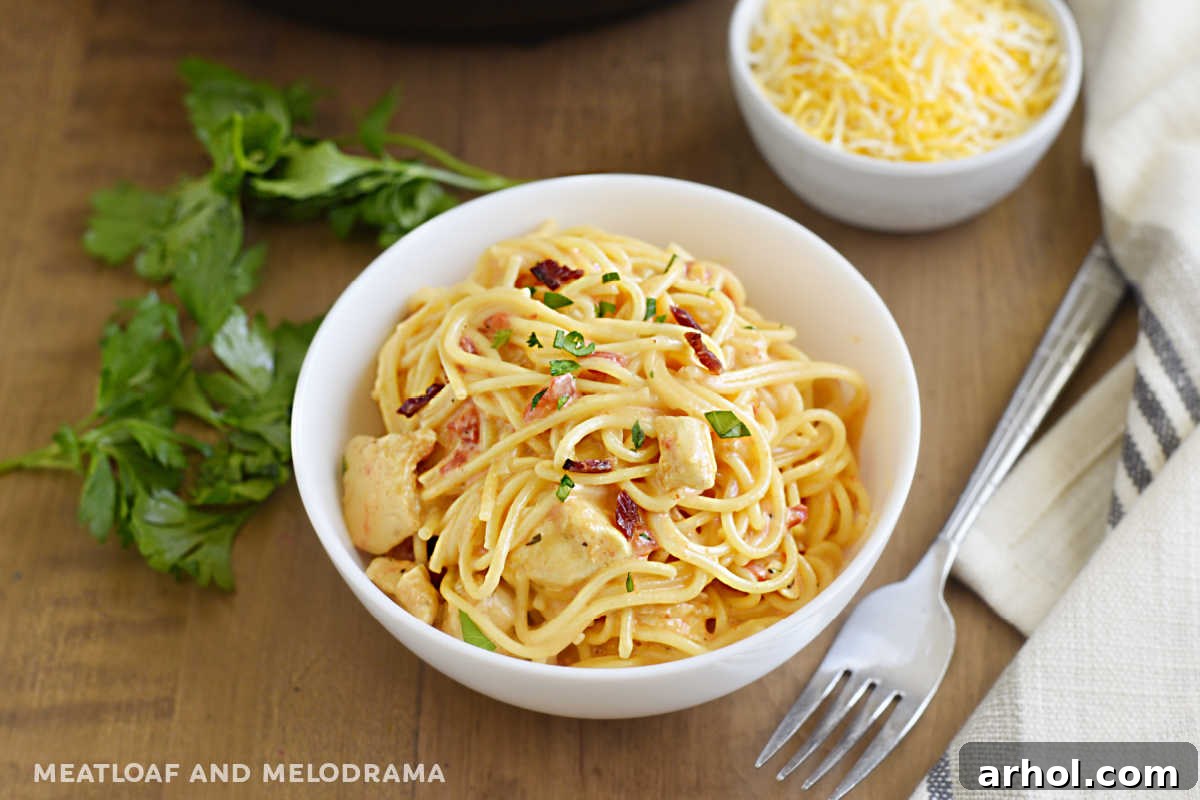 Creamy Instant Pot Chicken Spaghetti 11 A rustic bowl filled with Instant Pot Chicken Spaghetti, garnished with crispy bacon and fresh parsley, placed on a wooden table.