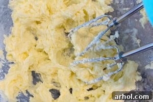 Creaming butter and sugar, then adding egg to the mixture for banana oatmeal cookies