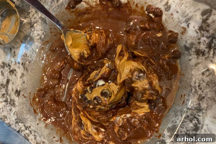 melted peanut butter and chocolate chips in a mixing bowl