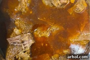 Beef chuck roast in cooking liquid in pressure cooker