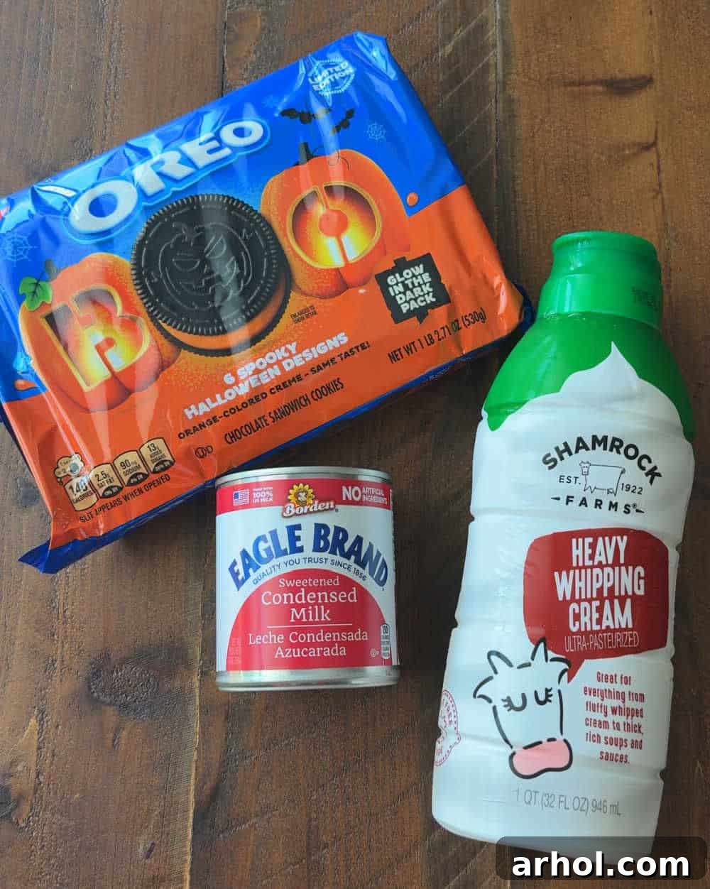 Key ingredients for homemade Halloween ice cream: Halloween Oreos, Eagle Brand sweetened condensed milk, and heavy cream displayed on a counter.