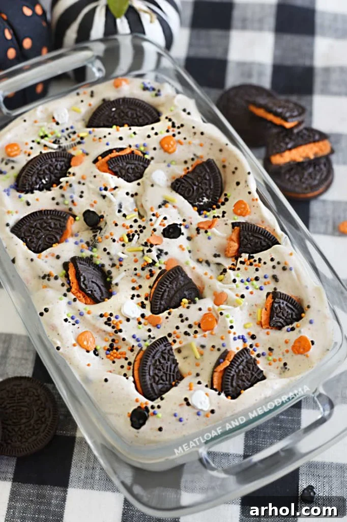 Homemade Halloween Oreo ice cream in a metal loaf pan, topped with crushed cookies and sprinkles, ready to be served.