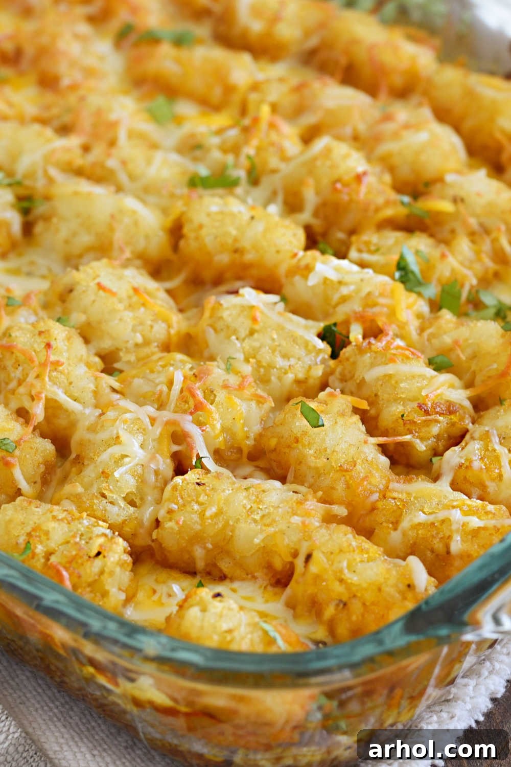 baked taco tater tot casserole with cheese and cilantro in casserole dish