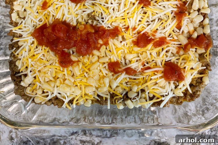 taco meat in baking dish with cheese and salsa on top
