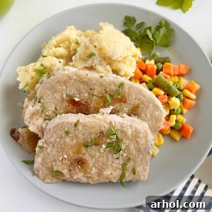 slices of slow cooker pork roast with apples on the table, garnished and ready to serve