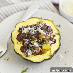 sausage stuffed acorn squash with apples and cranberries on a plate