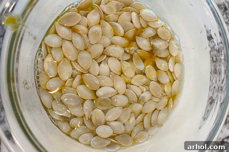 Pumpkin seeds soaking in a bowl of water to easily remove stringy pumpkin pulp.