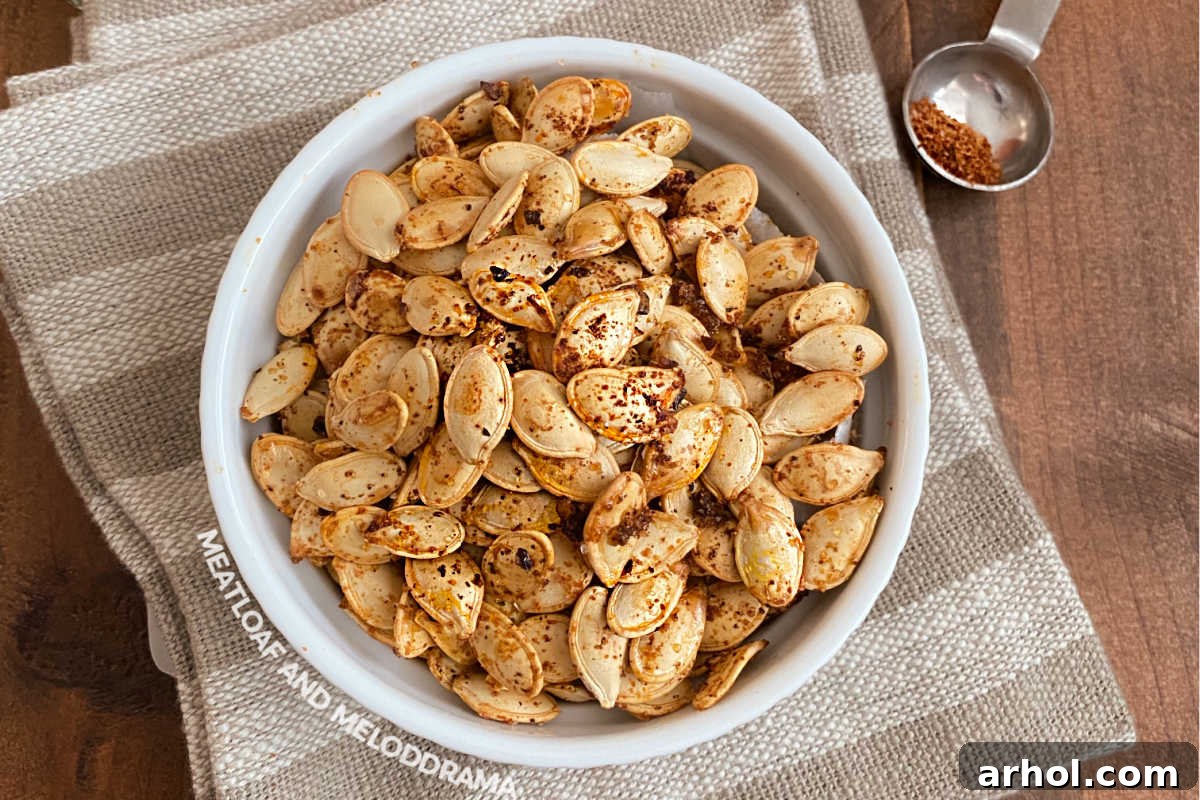 A white bowl filled with spicy roasted pumpkin seeds, seasoned with a vibrant taco blend.