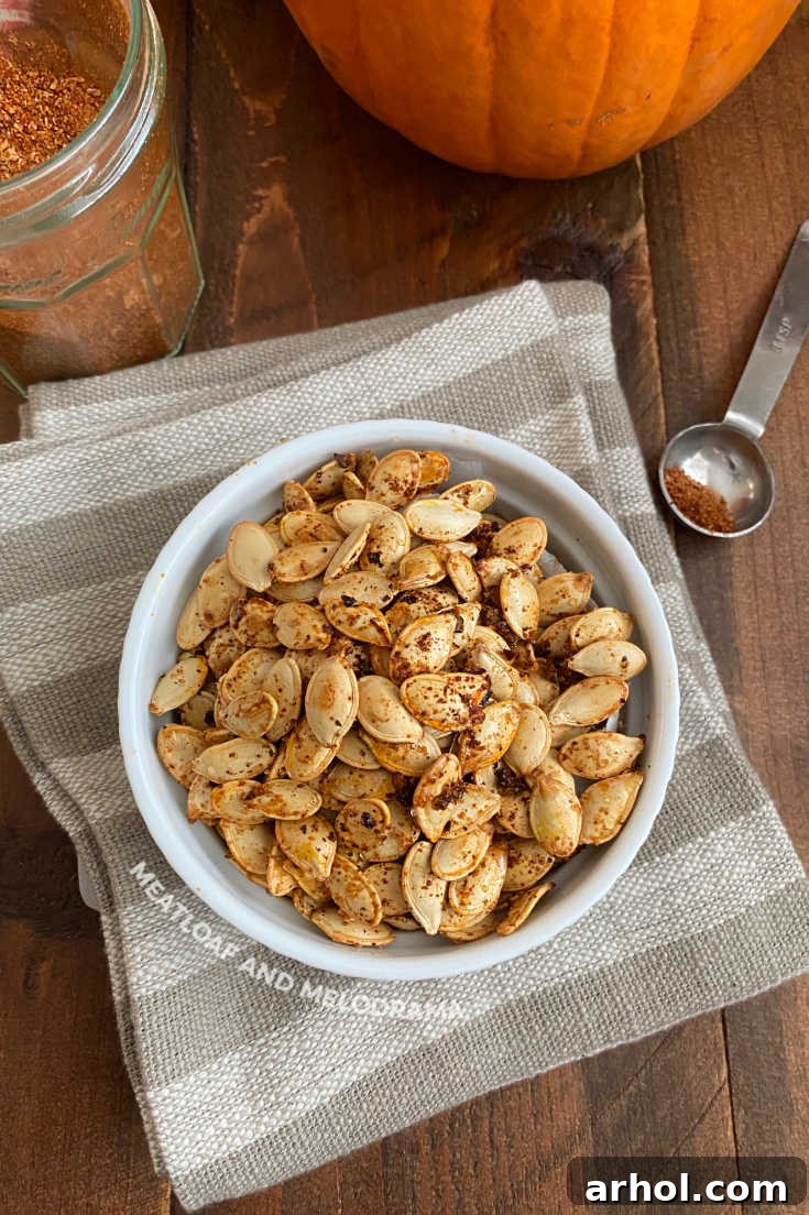 Close-up of roasted pumpkin seeds with a generous coating of taco seasoning in a white bowl.