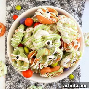 A bowl of Halloween pretzels featuring candy coating and festive candy eyes.