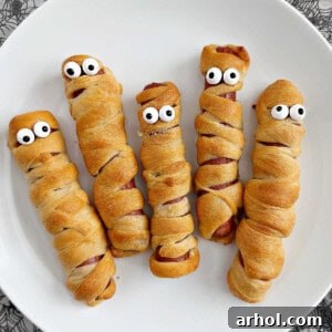 mummy dogs for halloween on a plate, resembling ancient mummies wrapped in bandages.