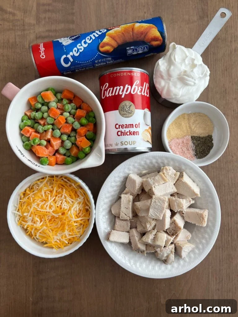 Ingredients for chicken pot pie casserole: cooked chicken, shredded cheese, frozen mixed vegetables, crescent rolls, sour cream, cream of chicken soup, and seasonings.