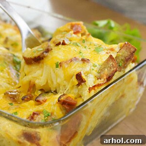 hashbrown breakfast casserole with hash brown potatoes and sausage on serving spoon