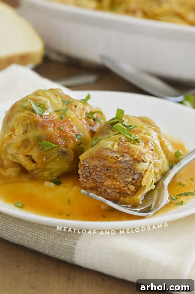 cut open cabbage rolls on a plate with fork, showing the delicious meat and rice filling.