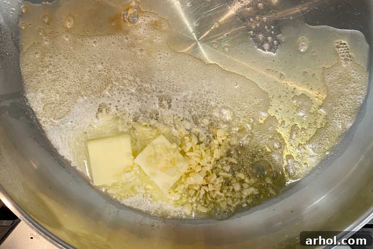 Sautéing chopped garlic in a mixture of butter and olive oil in a skillet