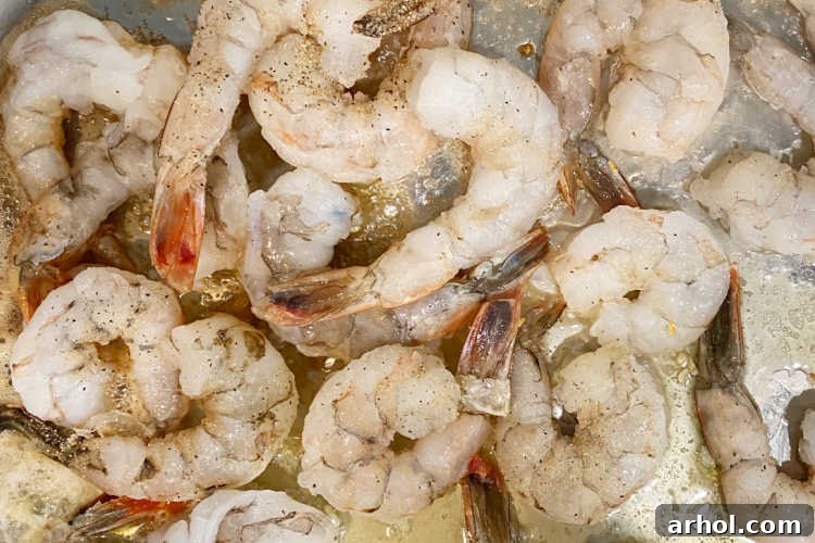 Raw shrimp cooking in a pan with fragrant garlic butter sauce