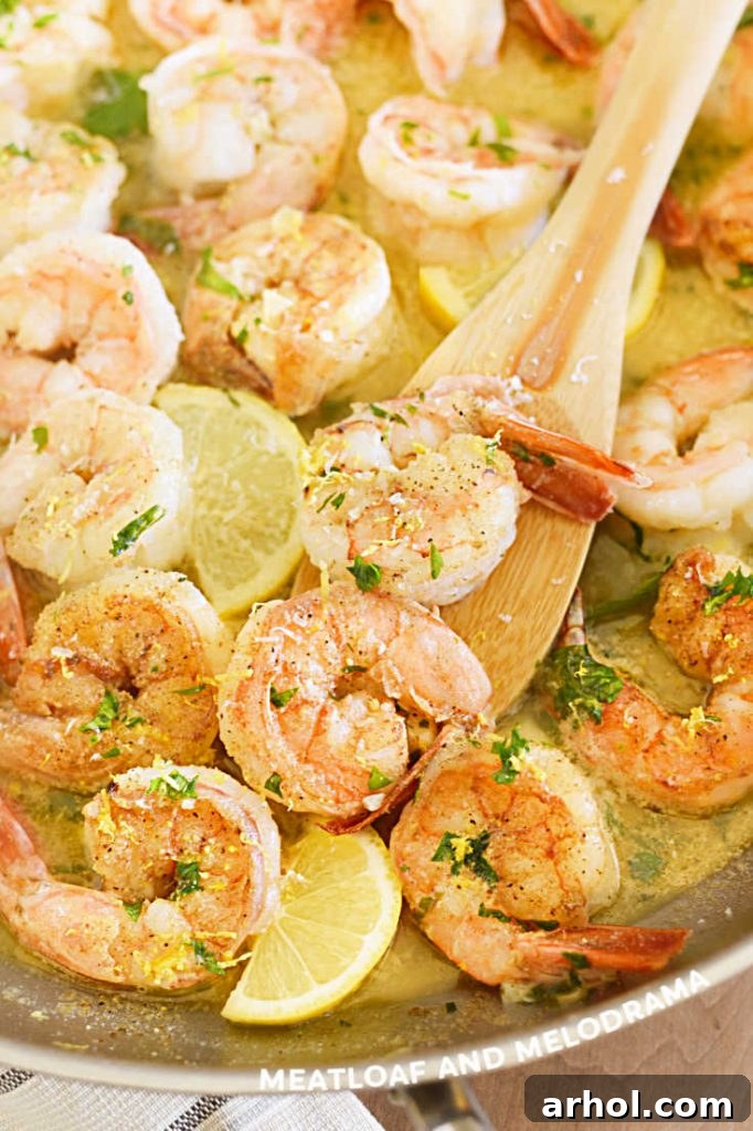 Shrimp scampi in a skillet with lemon slices and garlic butter sauce, ready to be served