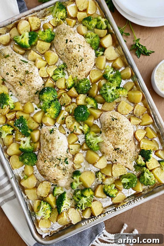 Effortless Ranch Chicken Sheet Pan 6 Close-up of baked ranch chicken, potatoes, and broccoli on a sheet pan, ready to be served.