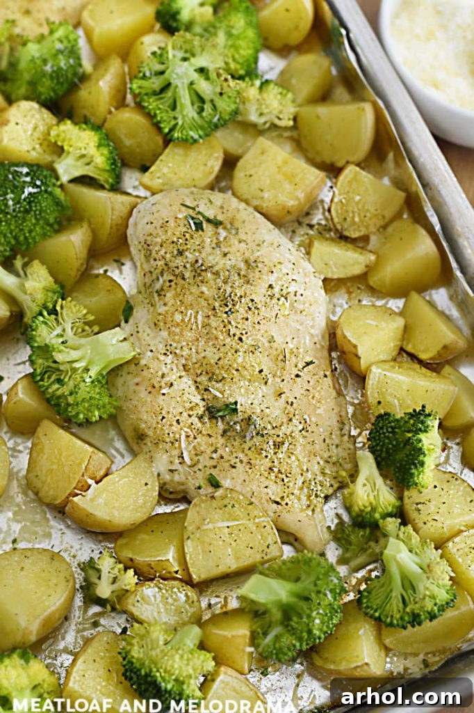 Effortless Ranch Chicken Sheet Pan 7 Serving of baked chicken with potatoes and broccoli, seasoned with ranch and Parmesan.