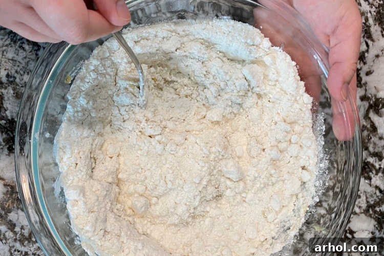 Mixing dry cake mix with mashed bananas in a bowl using a fork