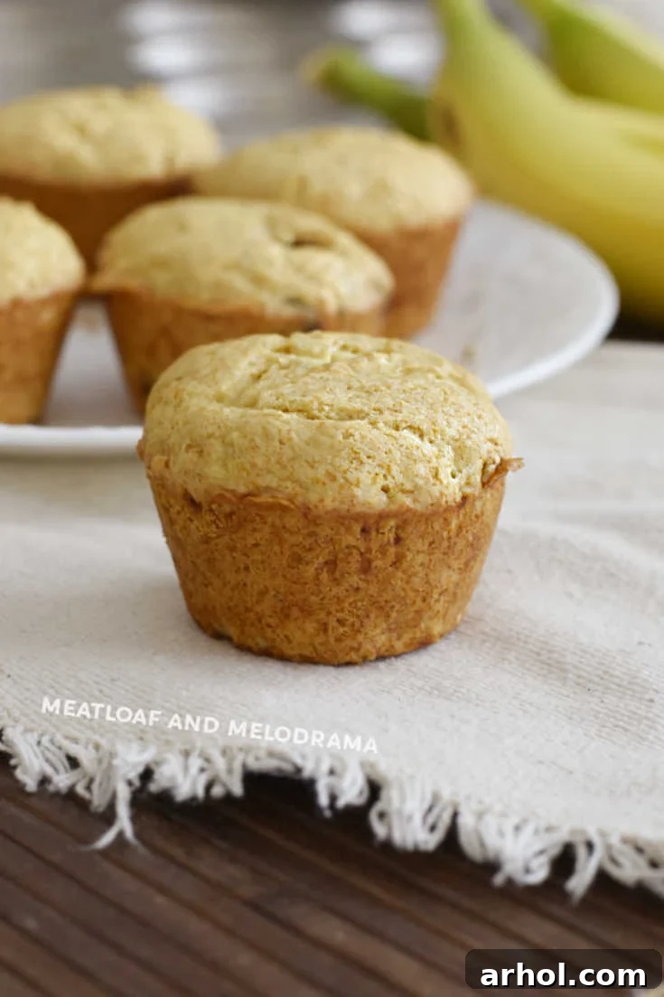 A single delicious banana muffin resting on a tan placemat, showcasing its fluffy texture
