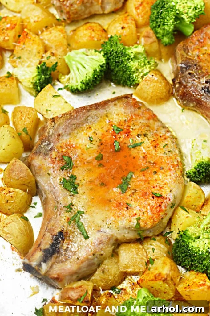 baked pork chop with paprika and potatoes and broccoli on a sheet pan