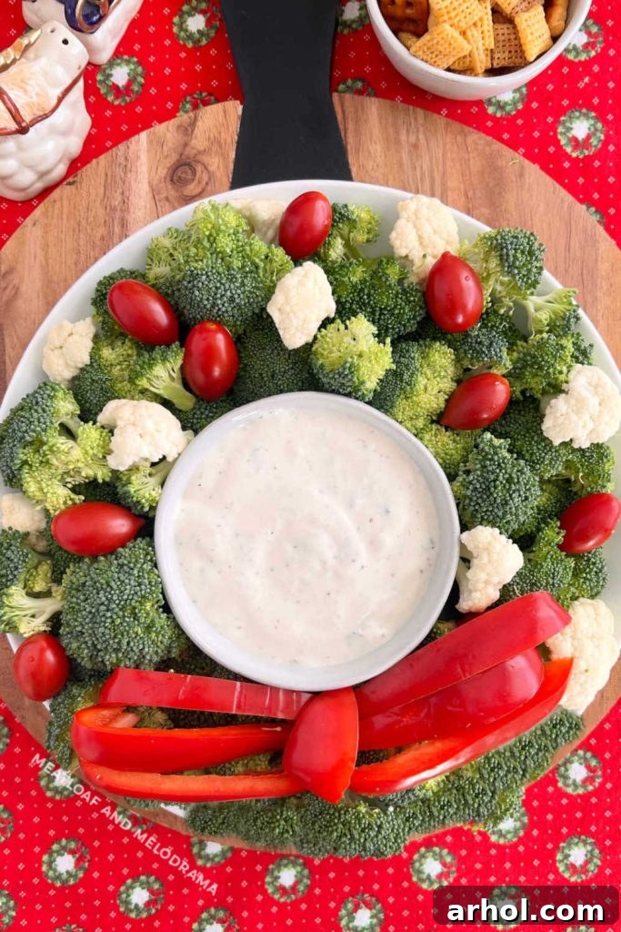 Festive Christmas Wreath Vegetable Platter with vibrant broccoli, cauliflower, cherry tomatoes, and red bell peppers