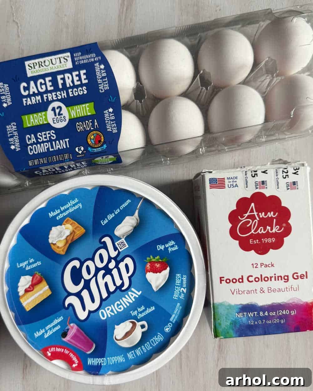 Essential ingredients for Cool Whip Easter eggs: white hard-boiled eggs, whipped topping, and an array of food coloring bottles.