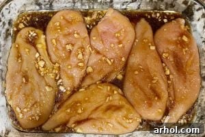 chicken breasts with garlic and honey soy sauce mix in a baking dish