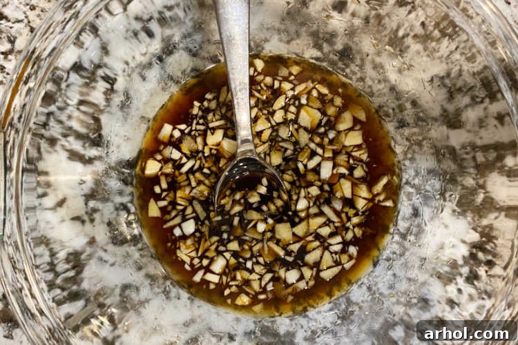 honey garlic sauce with chopped garlic in mixing bowl