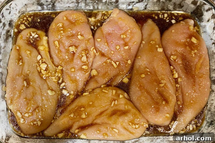 chicken breasts with garlic and honey soy sauce mix in a baking dish