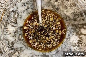 soy sauce, honey and vinegar in mixing bowl with chopped garlic