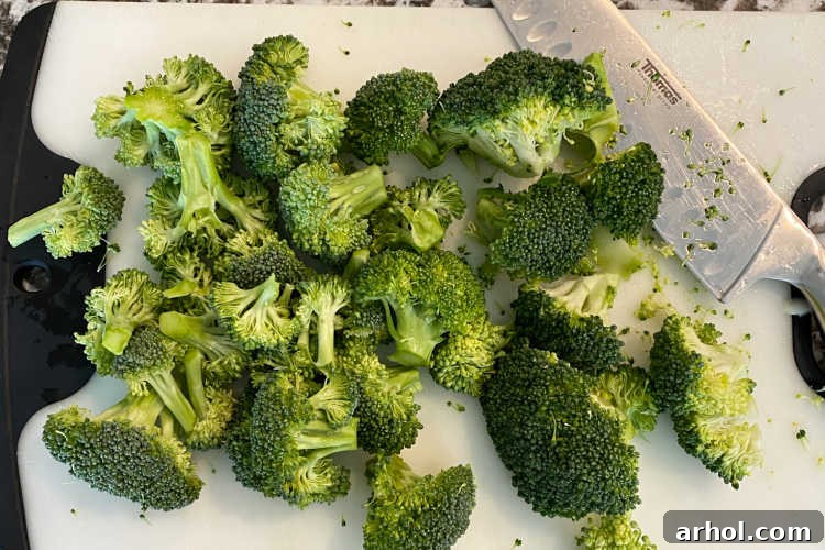 Chopped broccoli florets on a cutting board, ready for cooking